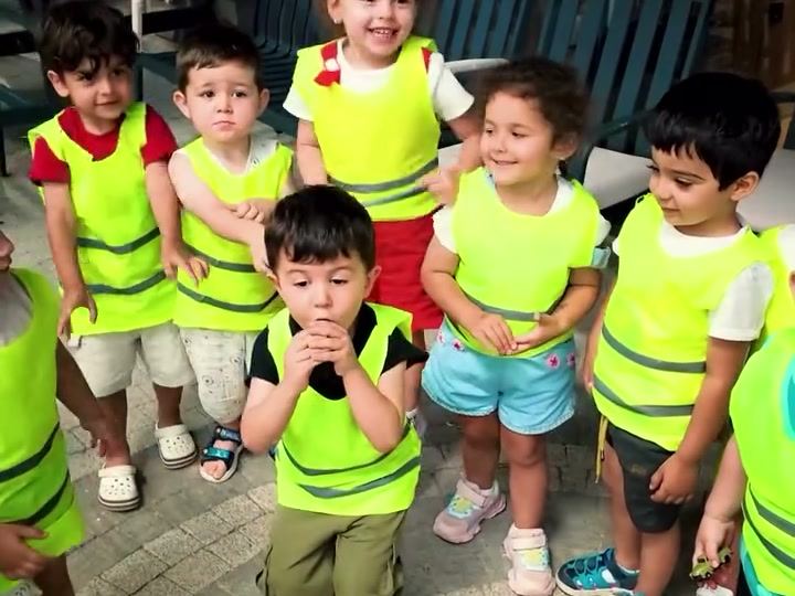 Sarı yelekli çocuklar gezi etkinliğinde bir arada